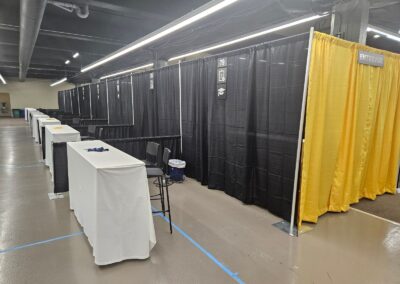 Salon de l’emploi avec kiosques et espaces d’entrevue séparés par des rideaux